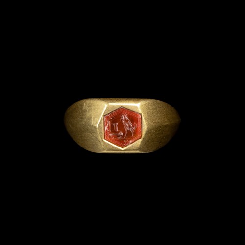 A gold ring set with a Roman carnelian intaglio. Rooster hunting a snake on a vase.